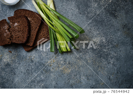 Bread with salt, green onions with water droplets Bread with salt, green onions with water droplets 76544942