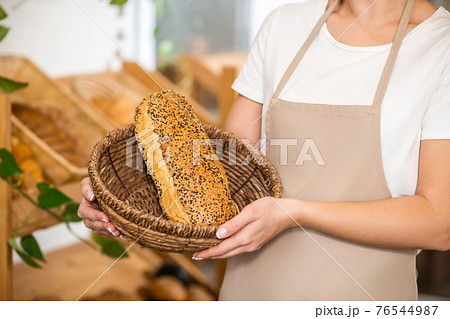 Female hands holding basket with loaf of bread Female hands holding basket with loaf of bread 76544987