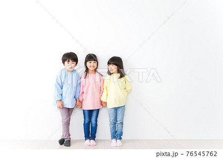 壁に並ぶ3人の幼稚園児 76545762