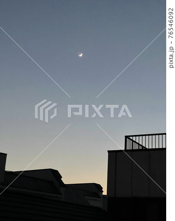 西の空に見える細い月 76546092