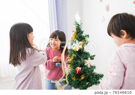 クリスマスの飾り付けをする子どもたち 76546610