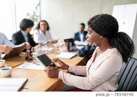 Black Businesswoman Using Digital Tablet Sitting During Corporate Meeting Indoor 76548746