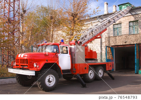 A large soviet red fire truck is preparing to leave. A large soviet red fire truck is preparing to leave. 76548793