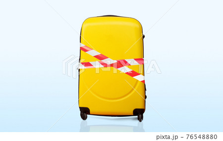 Colorful baggage wrapped in red and white barrier tape 76548880