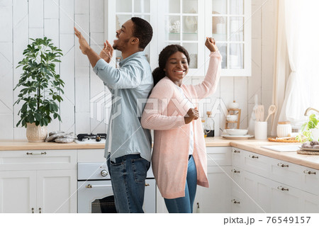 Domestic Fun. Portrait Of Energetic African American Couple Dancing In Kitchen Interior 76549157