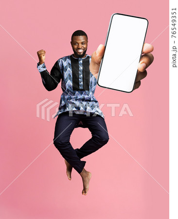 Check this out, cellphone display mockup. Excited black man showing smartphone with empty screen on pink background 76549351
