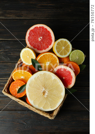 Basket with fresh citrus on wooden table Basket with fresh citrus on wooden table 76550772