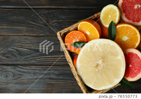 Basket with fresh citrus on wooden table Basket with fresh citrus on wooden table 76550773