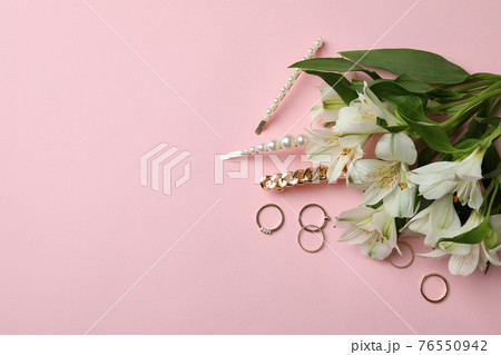 Jewelry and flowers on pink background, space for text Jewelry and flowers on pink background, space for text 76550942
