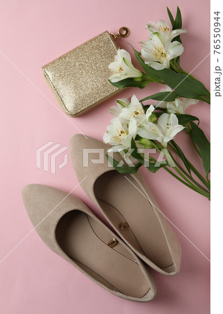 Womens shoes, cosmetic bag and flowers on pink background Womens shoes, cosmetic bag and flowers on pink background 76550944
