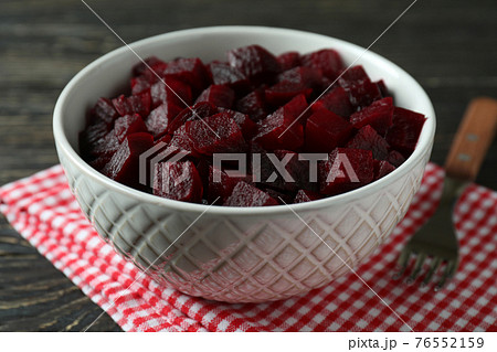 Bowl with beet salad, fork and kitchen towel on wooden background 76552159