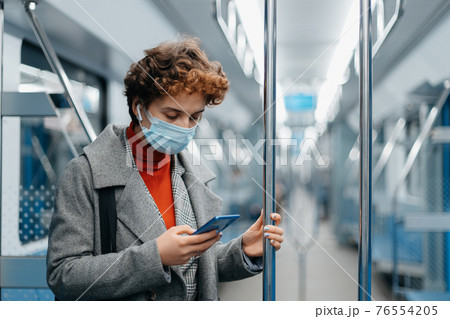 young woman using smartphone during subway ride. 76554205