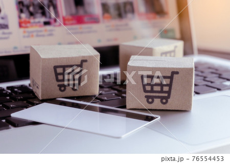 Online shopping. Credit card and cardboard box with a shopping cart logo on laptop keyboard. Shopping service on The online web. offers home delivery. Online shopping. Credit card and cardboard box with a shopping cart logo on laptop keyboard. Shopping service on The online web. offers home delivery. 76554453