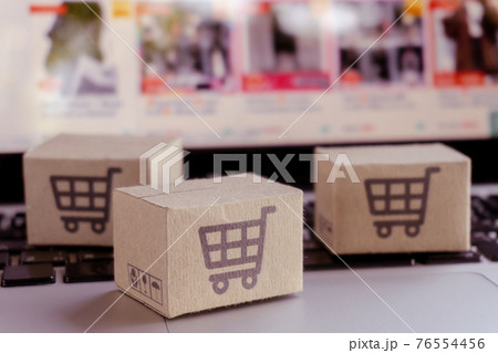 Online shopping. Cardboard box with a shopping cart logo on laptop keyboard. Shopping service on The online web. offers home delivery 76554456