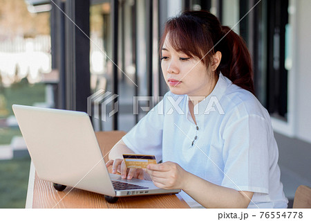 Online Payment . Asian woman holding credit card and using laptop with online shopping. Home shopping Online Payment . Asian woman holding credit card and using laptop with online shopping. Home shopping 76554778