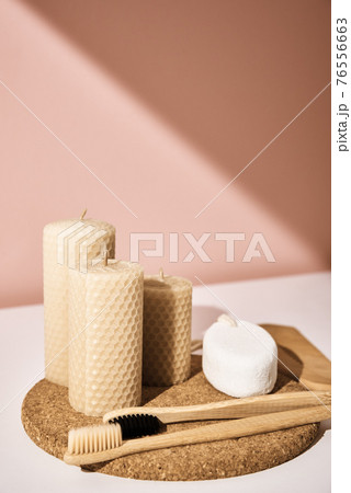 Bamboo toothbrushes with candles on pink background Bamboo toothbrushes with candles on pink background 76556663