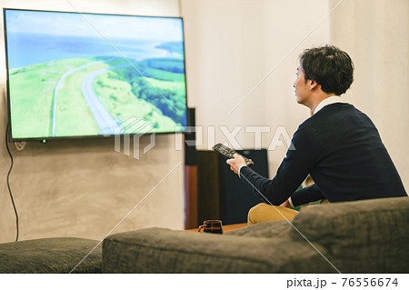 ホームシアターでテレビを見る男性 76556674