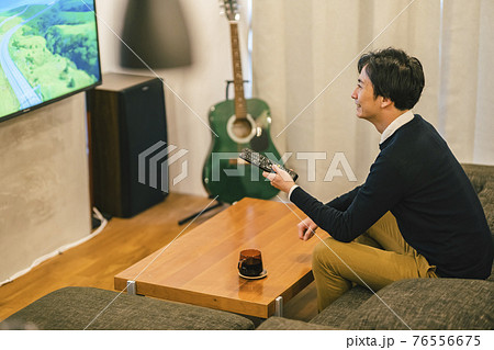 ホームシアターでテレビを見る男性 76556675