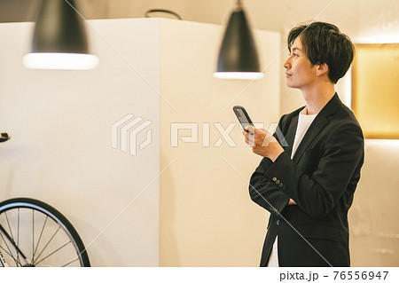 スマホを見る男性 スマホを見る男性 76556947