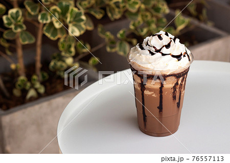 Mocha frappe in plastic cup. Served with whipping cream and chocolate sauce. Freshness drink. Favorite caffeine beverage menu. 76557113
