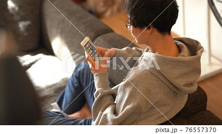 ソファで蘇まほを見る男性 76557370