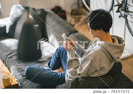 ソファで蘇まほを見る男性 ソファで蘇まほを見る男性 76557372