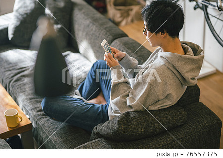 ソファで蘇まほを見る男性 ソファで蘇まほを見る男性 76557375