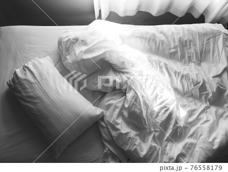 Messy bed. Unmade pillow and blanket sheet on bed. Messy bed. Unmade pillow and blanket sheet on bed. 76558179