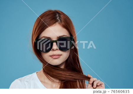 Pretty woman in sunglasses charm long hair white t-shirt blue background Pretty woman in sunglasses charm long hair white t-shirt blue background 76560635