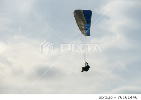 Man doing sport, Para-glider in the clouded sky. 76561446