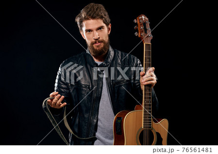 A man with a guitar in his hands leather jacket music performance rock star modern style dark background A man with a guitar in his hands leather jacket music performance rock star modern style dark background 76561481