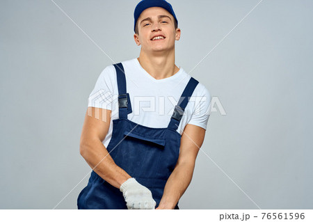 Man worker in forklift uniform delivery service light background Man worker in forklift uniform delivery service light background 76561596