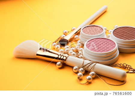 Eyeshadows on a yellow background professional cosmetics makeup brushes soft sponge fashion glasses 76561600