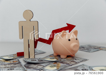 Piggy bank and wooden person with arrow up on dollar banknotes. Investment concept 76561900
