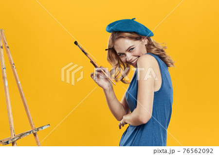Artist woman in blue beret brush easel art drawing education hobby Creative approach yellow background Artist woman in blue beret brush easel art drawing education hobby Creative approach yellow background 76562092