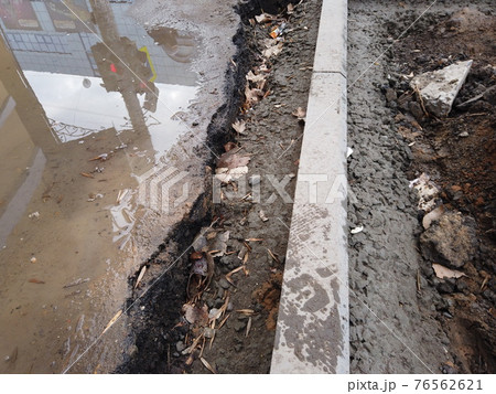 Installation of new curbstones in the street above view. Curbstone immersed in concrete 76562621