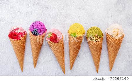 Various of ice cream flavor in cones blueberry ,pistachio ,almond ,orange and cherry setup on white stone background . Summer and Sweet menu concept. 76567140