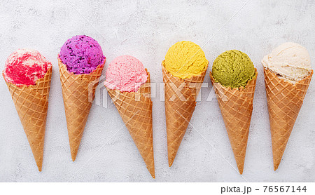 Various of ice cream flavor in cones blueberry ,pistachio ,almond ,orange and cherry setup on white stone background . Summer and Sweet menu concept. 76567144