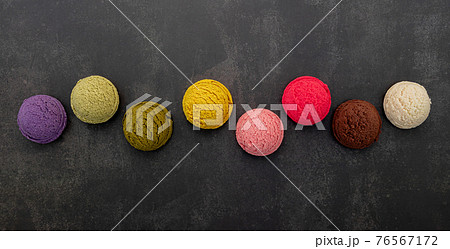 Various of ice cream flavor blueberry ,pistachio ,almond , orange, green tea and chocolate setup on dark stone background . Summer and Sweet menu concept. 76567172