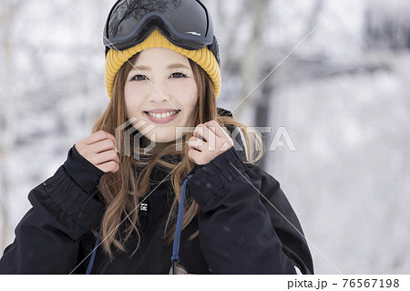 雪の降るスキー場で笑顔で立つスノボ女子の写真素材 76567198 Pixta