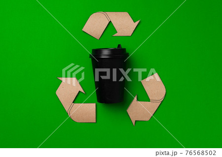Disposable coffee cup and recycling sign on green background Disposable coffee cup and recycling sign on green background 76568502