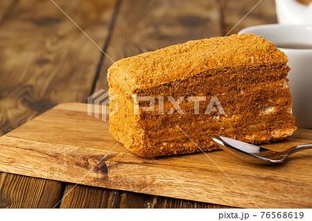 Piece of honey cake on kitchen table 76568619
