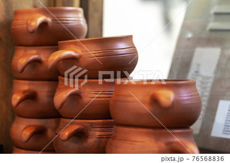 Clay pots on a wooden shelf close up Clay pots on a wooden shelf close up 76568836