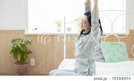 伸びをする笑顔のミドル女性 76568954