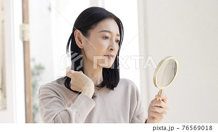 美容・ビューティー　髪を触るミドル女性 76569018