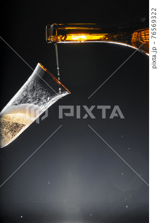 Champagne pouring into glass on black background Champagne pouring into glass on black background 76569322