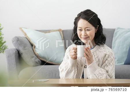 マグカップ を持った笑顔の60代半ばの女性 76569710