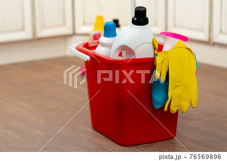 Various household cleaning detergents and bottles in a plastic bucket on the floor Various household cleaning detergents and bottles in a plastic bucket on the floor 76569896