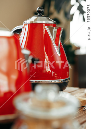 Red kettle on kitchen table close up 76570078