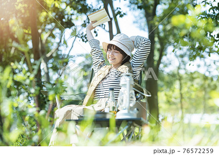 ソロキャンプイメージ・本を読む若い女性 76572259